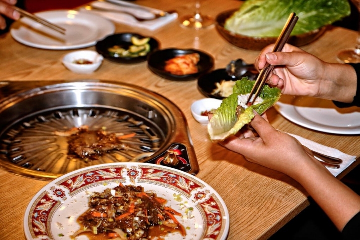 El comensal se hace su propia comida en una planca ubicada en la mesa.