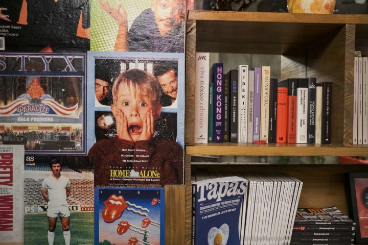 Pósters de películas, series y revistas en una pared del local.