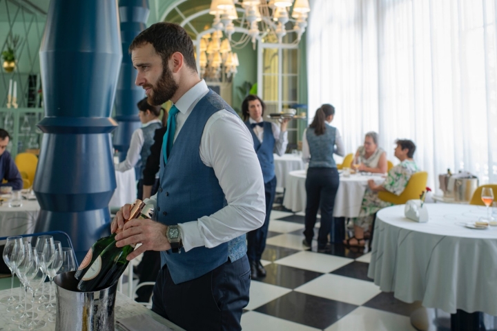 La sala, luminosa y animada, con suelos en damero y mucho color