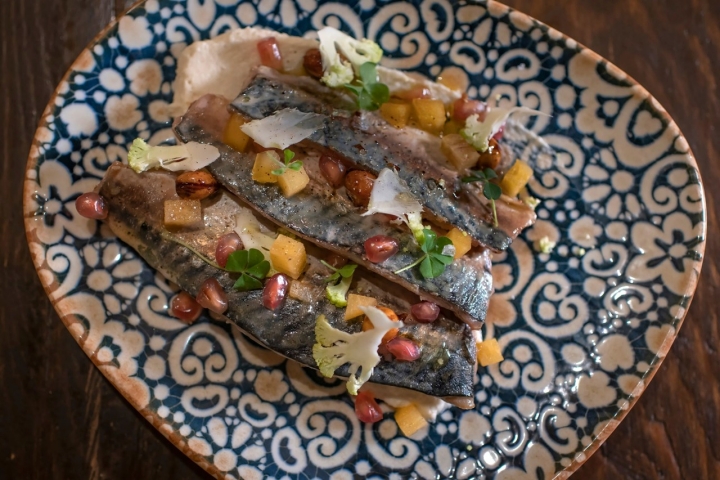 Caballa confitada ahumada con puré de coliflor, granada y caqui, siempre que el producto esté en temporada.