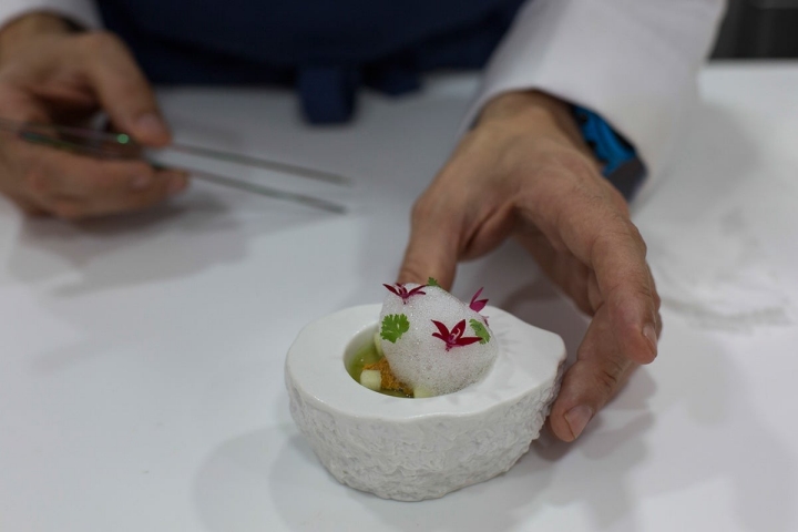 El cocinero trabajando en uno de sus platos: Erizo de mar Royal con velo de apio y aire de lima.