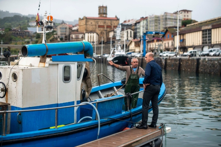 Faustino ha salido temprano a pescar salmonetes. Aitor le recibe a su vuelta en el puerto.