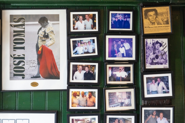 Una gran colección de fotografías cubren la pared principal de su bar.