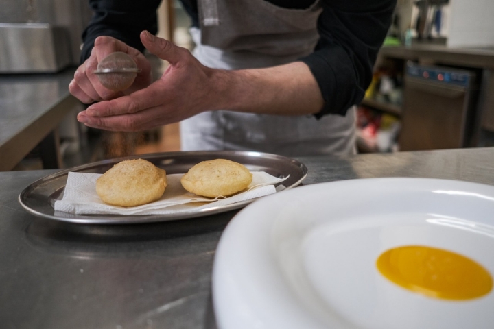 Ángel emplata su versión de migas extremeñas que van sobre yema de huevo.