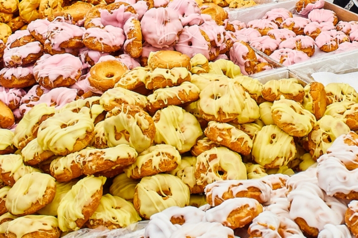 Madrid, Spain - May 15, 2018. Bakers selling Rosquillas del Santo, typical Spanish sweet, in a bakery stall at the San Isidro festivity fair in Pradera de San Isidro park of Madrid.