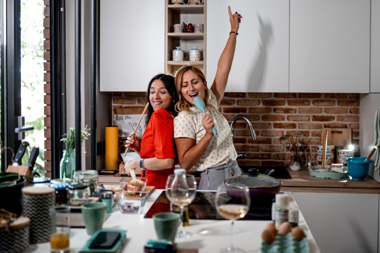 Dos chicas cantan en la cocina.