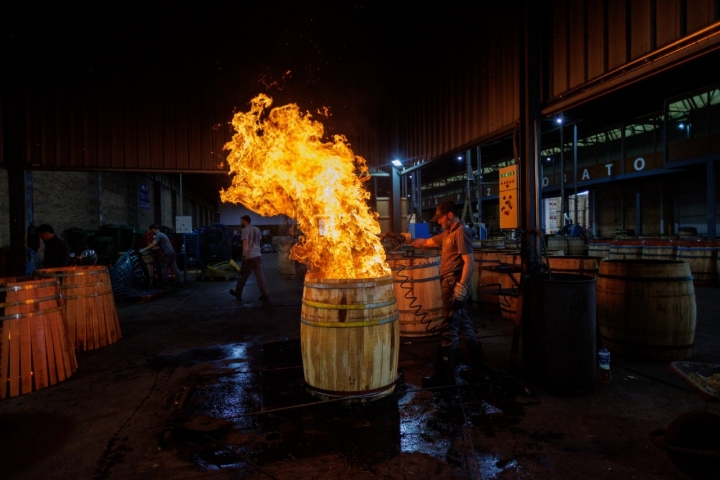 Un operario tuesta el interior de una barrica