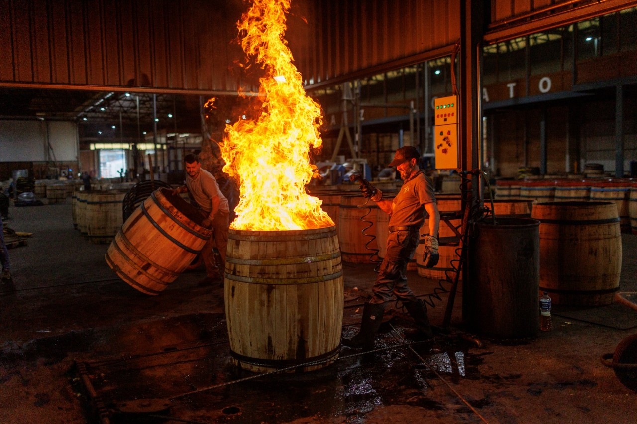 Un operario tuesta el interior de una barrica