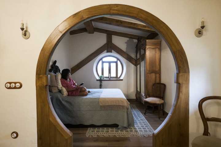 Mujer sentada en la cama de la habitación El Carpintero