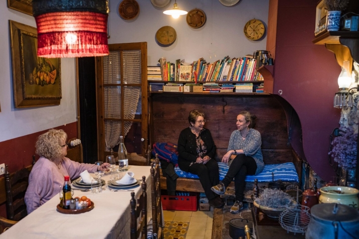 Las propietarias junto a una vecina charlando en la cocina de Casa Leonardo