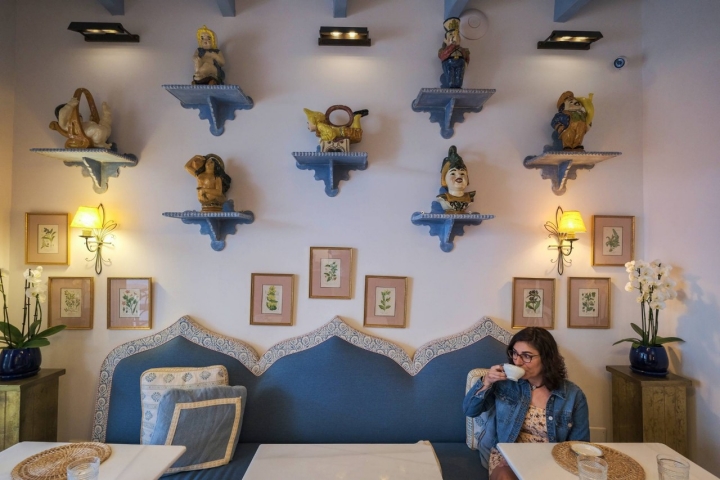 Una mujer toma un café en la sala utilizada para desayunos y cenas.