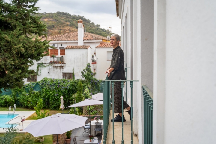 Una huésped del hotel Luz Almonater asomada a uno de los balcones