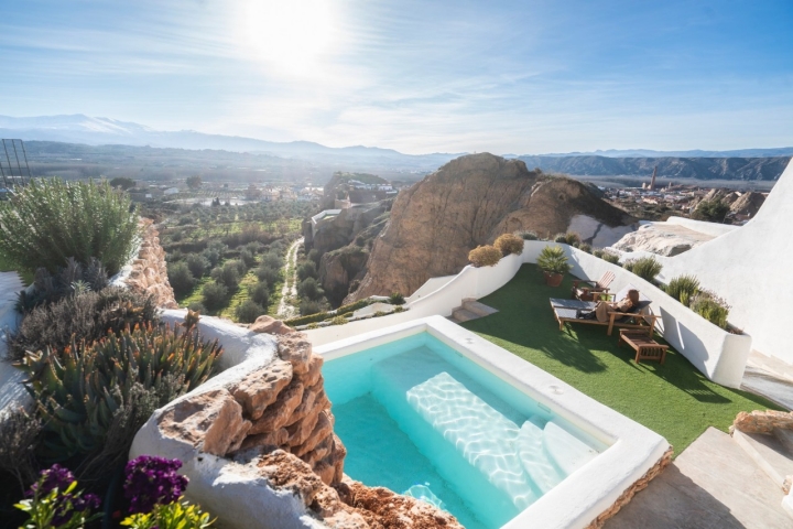 Una piscina devuelve el reflejo del paisaje.