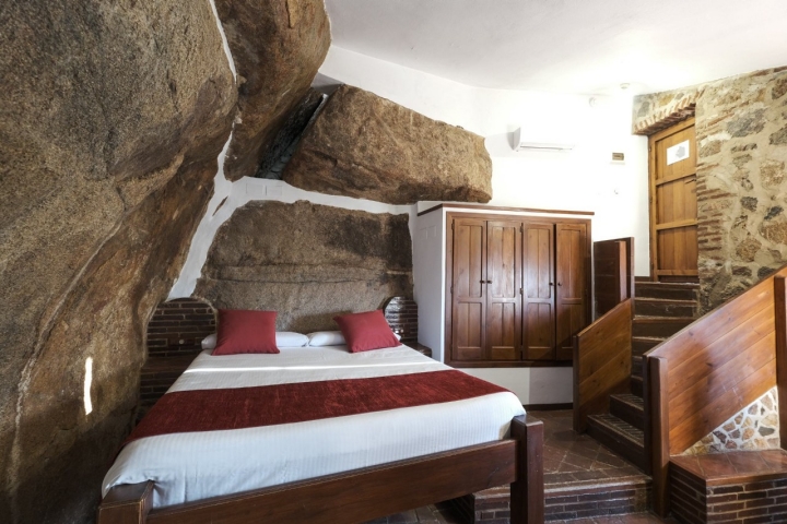 Una habitación doble en la que las rocas están integradas como pared.