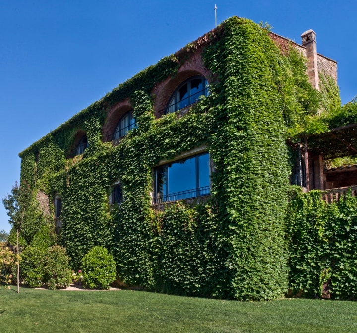 La masía, cubierta de hiedra, espera a los visitantes.