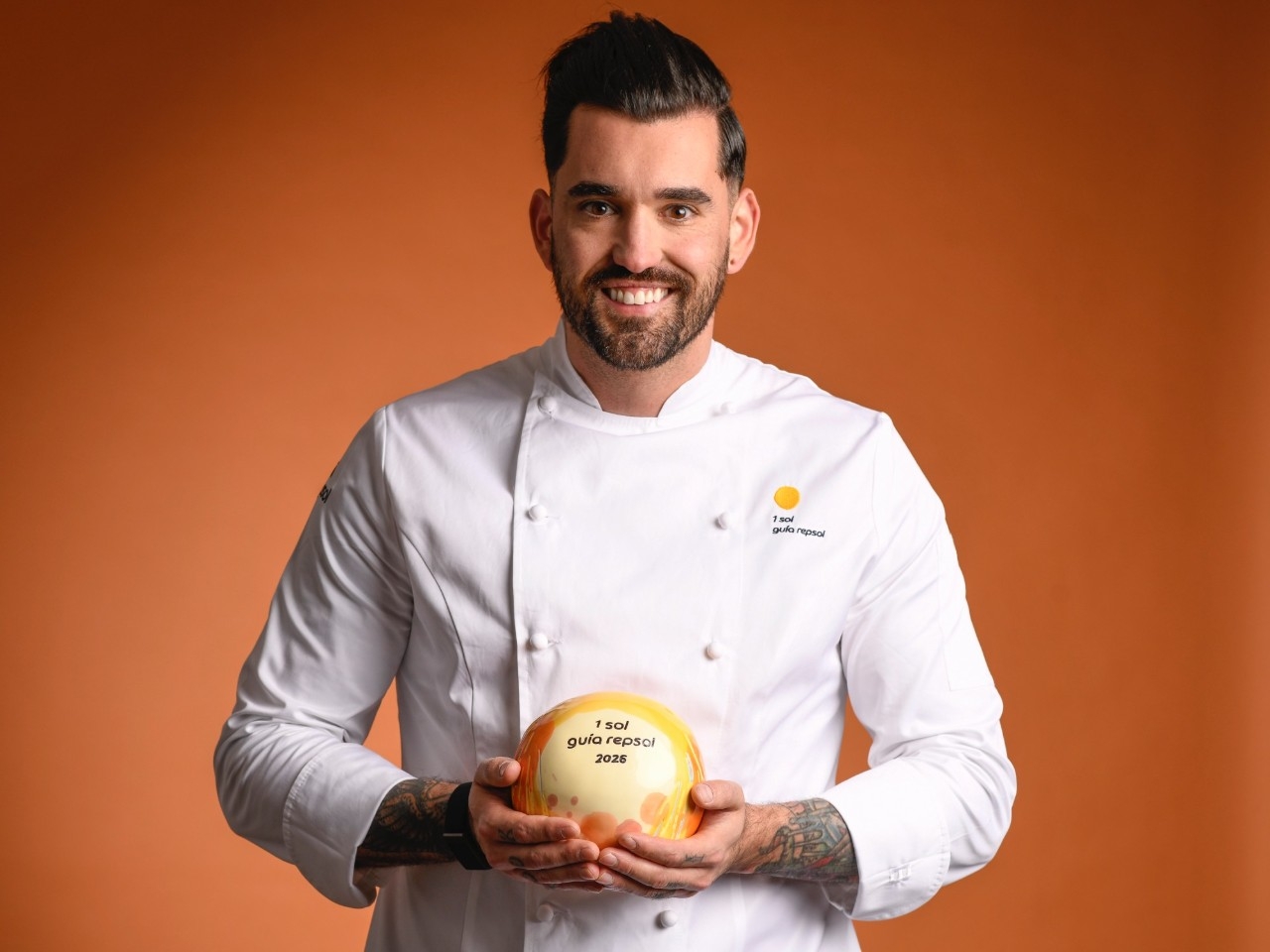 El cocinero Jordi Grau posa con el galardón de Un Sol Guía Repsol.