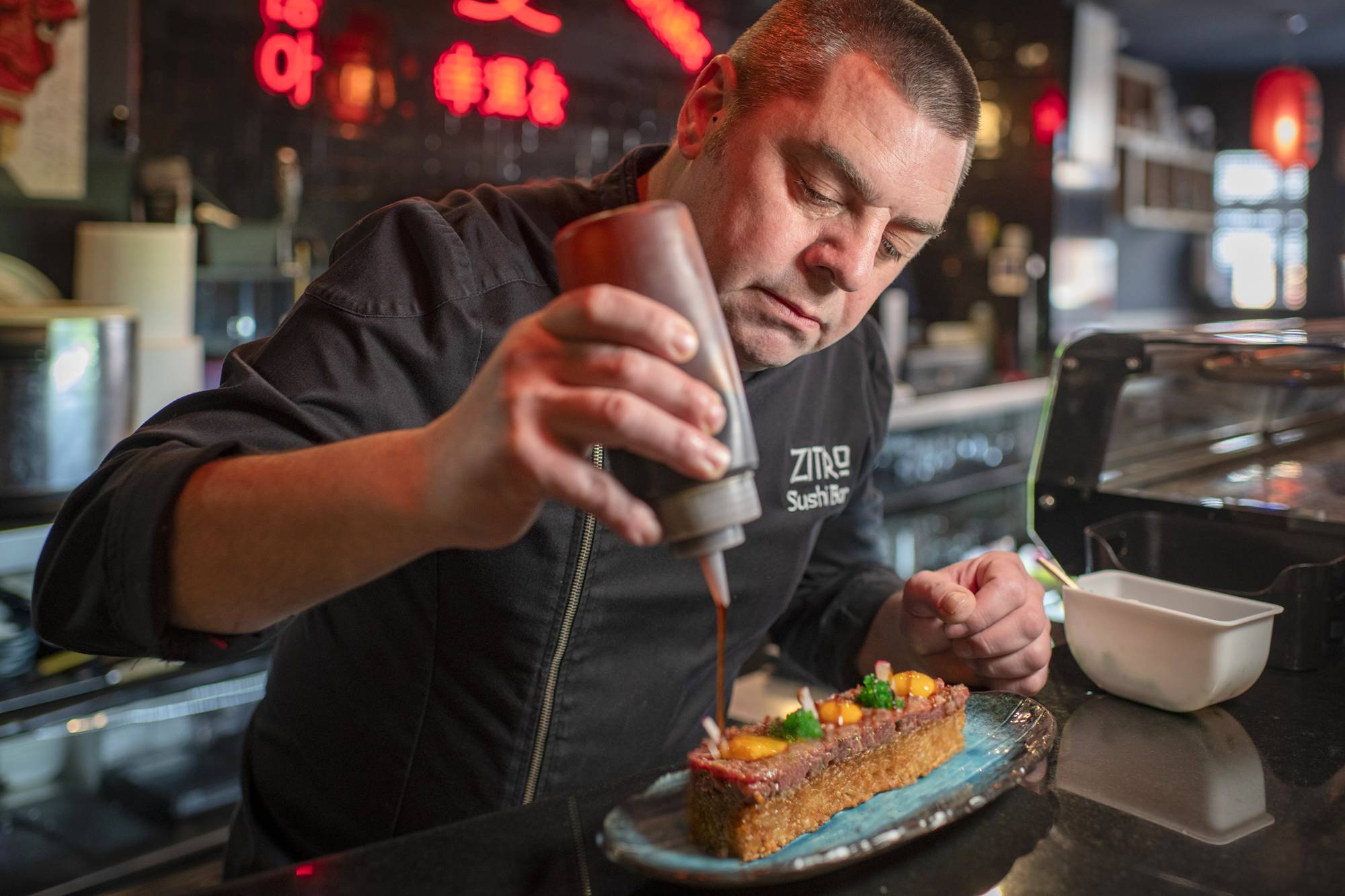 Rubén Ortiz termina un original steak tartar en la barra de su restaurante asiático ‘Zitro’, en Tomelloso. (Ciudad Real, Castilla-La Mancha). Foto: Sofía Moro