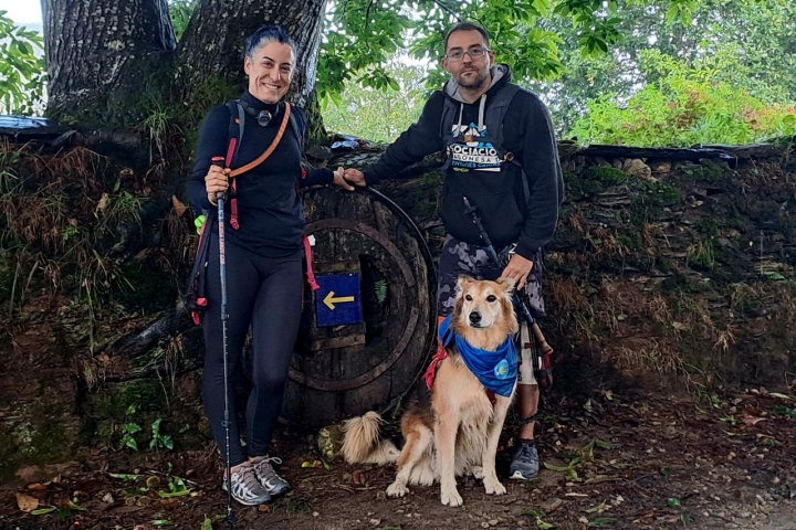 Peregrinos del Camino de Santiago junto a su perro.
