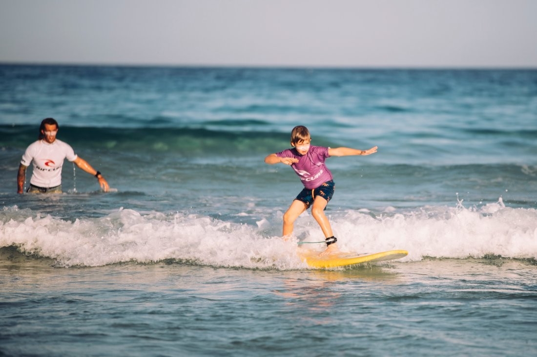 Surf con niños en Fuerteventura: Matías cogiendo olas