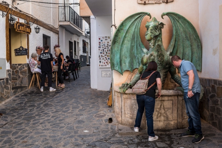 El dragón que preside la fuente parece abrazar a los curiosos en Soportújar.