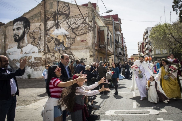 Los asistentes extienden las manos para recoger las flores que se lanzan el Domingo de Resurreción.