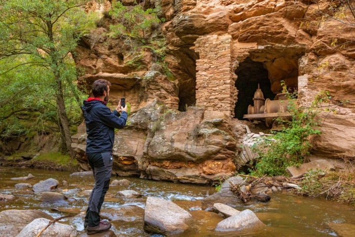 Un hombre fotografía restos de maquinaria de la Presa de Santa Marta (Guadalajara).