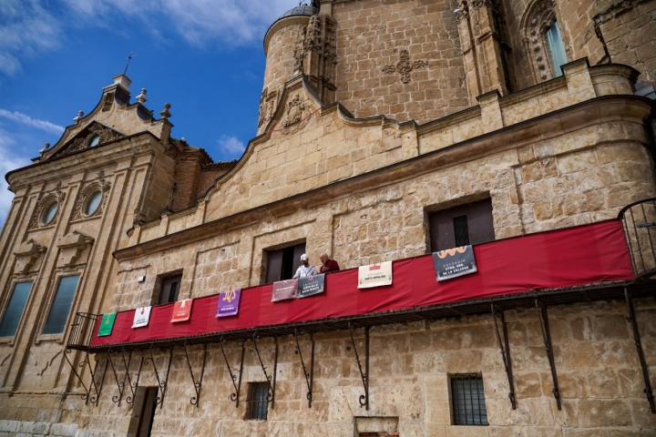 Sobre los balcones de la iglesia, que se alquilaban para poder disfrutar de los espectáculos taurinos, cuelgan las insignias de las cofradías, que anunciían la cercanía en el calendario de la Semana Santa.