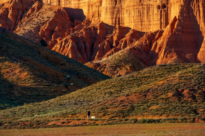 Hombre caminando con los escarpados paisajes de Barrachina de fondo