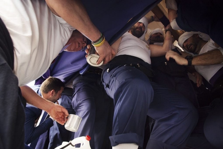 El aguador da un refresco a los costaleros de la Hermandad de San Benito. Foto: Ayto. Sevilla