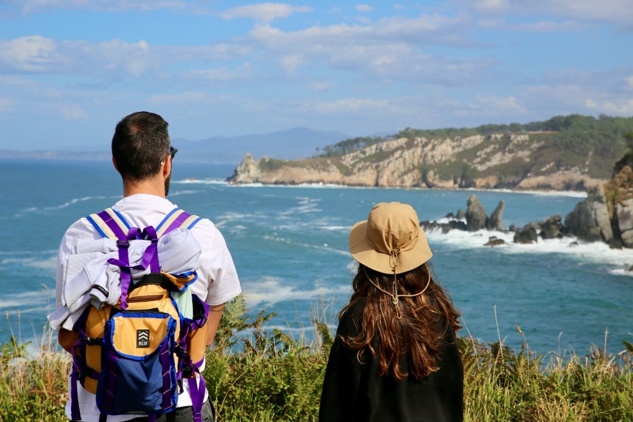 Dos senderistas se asoman a un mirador de la Senda Costa Naviega